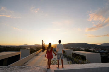 Couple Watching a Sunset on a Rooftop With Beautiful Landscape