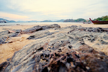 Scenic Ocean View with Rocky Shore and Distant Boats Under Serene Skies