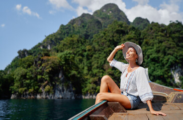 Woman Relaxing on a Boat Amidst Scenic Island Landscape