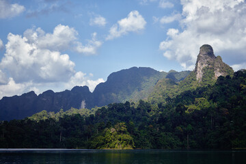 Scenic View of Verdant Jungle With Towering Mountain Peaks and Blue Sky