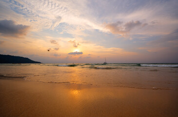 A scenic sunset view over a tranquil beach, showcasing golden sands, gentle waves, and a beautiful sky with warm color tones that inspire peace and calmness.