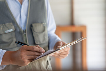 inspector or engineer is inspecting construction and quality assurance new house using a checklist....