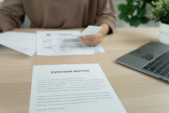 woman is stressed due to imminent seizure of assets, debts, financial problems, loans, guarantees document with the text eviction notice, debt, property, loan, agent, bankruptcy