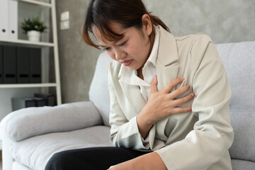 hand hold chest with heart attack symptoms, business woman working hard have chest pain caused by...