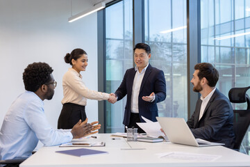 Business people shaking hands, sealing a deal in a modern office setting. Collaboration and...