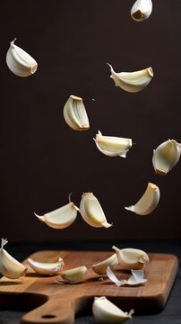 falling garlic, close up garlic on black background, slow motion
