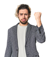 Young businessman in casual blazer showing fist to camera, aggressive facial expression.