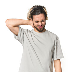 Young Caucasian man in studio setting suffering neck pain due to sedentary lifestyle.
