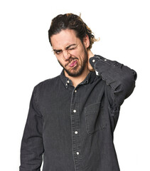 Young Caucasian man in studio setting suffering neck pain due to sedentary lifestyle.