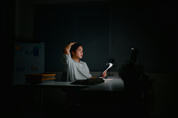Tired office worker struggling with project during late hours