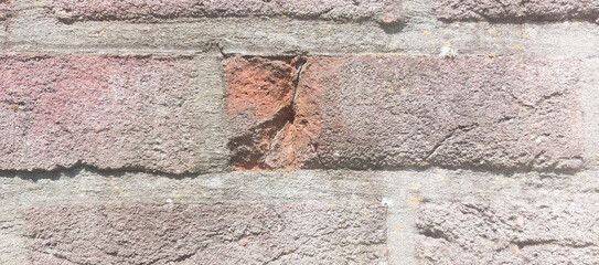 Chip inside a brick on a Weathered brick wall showing different textures. Close-up