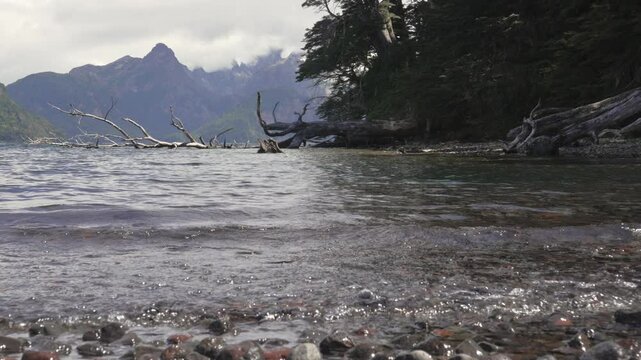 Static view of Tromen Lake Shoreline with Subtle Waves and Scenic Mountain Backdrop. Lanin National Park, Neuquen, Argentina