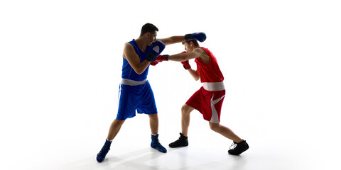 Two boxers in contrasting red and blue uniforms are engaged in a competitive bout on a white background. Concept of sportsmanship and competition.