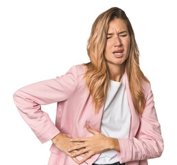 Young blonde in stylish pink suit having a liver pain, stomach ache.