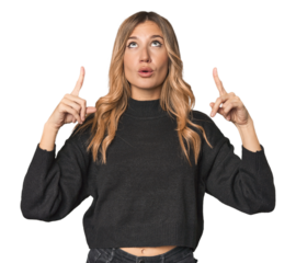 Caucasian blonde woman in studio pointing upside with opened mouth.