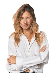 Caucasian blonde woman in studio frowning face in displeasure, keeps arms folded.