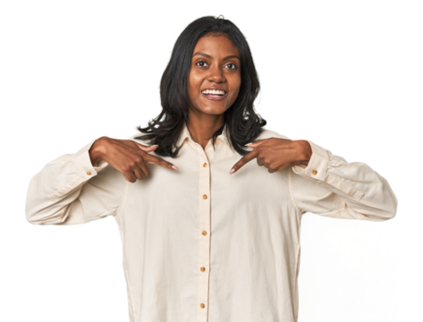 Portrait of a young Indian woman surprised pointing with finger, smiling broadly.