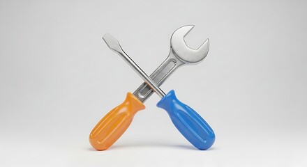 A wrench and a screwdriver crossed against a plain white studio background view