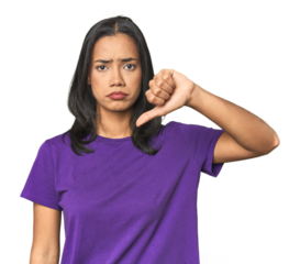 Young Latina posing in studio showing a dislike gesture, thumbs down. Disagreement concept.