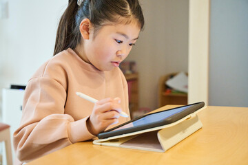 デジタルペンでタブレットを使う少女