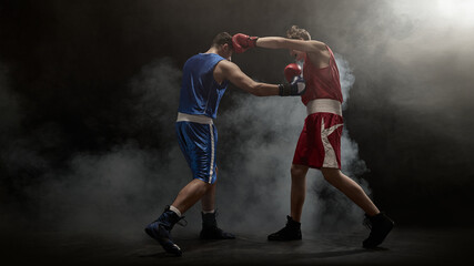 Boxers in action deliver punches amid a smoky boxing ring atmosphere. Concept of intense sports...