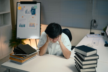Exhausted businessman stressed over workload at night