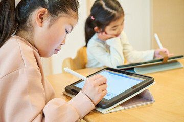タブレット学習に集中する姉妹