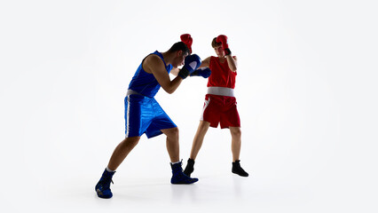 Two boxers wearing red and blue gear are sparring on a white background. Concept of athletic competition and sportsmanship.