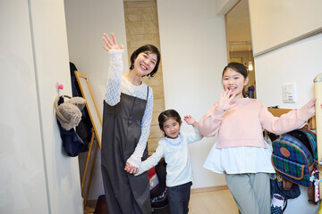 玄関で挨拶する親子の笑顔