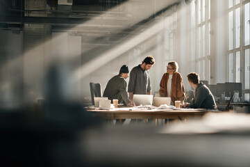 confident leader standing in bright office engaging with diverse team