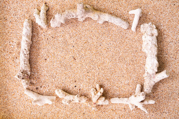 Coral dead on the beach sand forms a square frame with an empty space in the middle