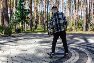 child riding a steak in the park, skateboarding, summer vacation in the park, boy riding a skateboard close-up