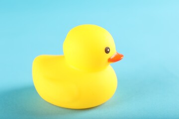 One cute rubber duck on light blue background, closeup