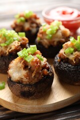 Delicious stuffed mushrooms and sauce on table, closeup