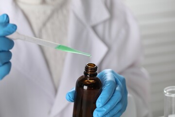 Professional perfumer developing luxury perfume in laboratory, closeup