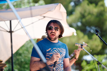 Rock band performs lively set outdoors amidst sunny atmosphere