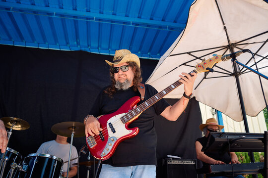 Rock band performing at outdoor venue with upbeat energy and style