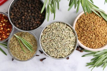 Different aromatic spices on white table, flat lay