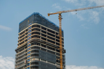 tall building under construction with crane in Chongqing, China