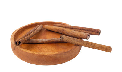 cinnamon sticks in a wooden plate on white background isolated