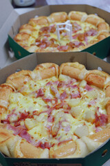 pizza with ham, by cut to pieces on table. selective focus on the filling close-up.
