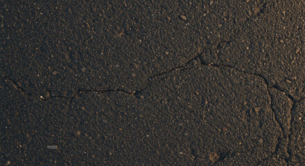 Obraz premium Crack in dark asphalt surface texture