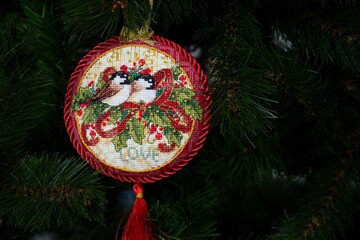 Cross stitched Christmas Old World Holiday Ornament on a Christmas tree. This round Christmas...