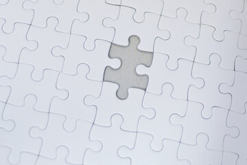 White jigsaw puzzle pieces connect to create a solution for teamwork and business success in this abstract concept illustration.