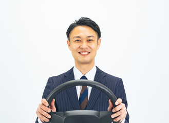 ハンドルを持って笑顔で運転するミドルエイジ男性ビジネスパーソン