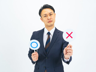 バツ印を見せるミドルエイジ男性ビジネスパーソン