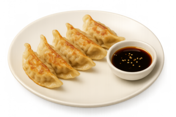 Four fried gyoza dumplings served on a white plate with soy sauce and sesame seeds on transparent background