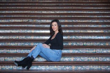 Young, pretty, brunette woman in black long sleeved t-shirt and jeans, relaxed and calm, posing...
