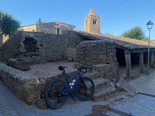 Blue bicycle parked on medieval ruins in a village in Girona in a Cycling Tour in Catalonia