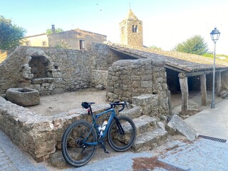 Blue bicycle parked on medieval ruins in a village in Girona in a Cycling Tour in Catalonia